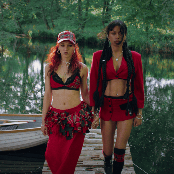Nova Twins - Photo Credit - Fin Frew - Two women in red outfits standing on a dock