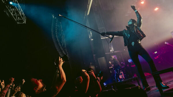 Will Gould reaching out to the crowd under blue light as Creeper play the O2 Forum Kentish Town