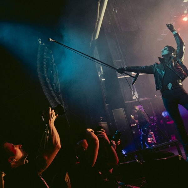 Will Gould reaching out to the crowd under blue light as Creeper play the O2 Forum Kentish Town
