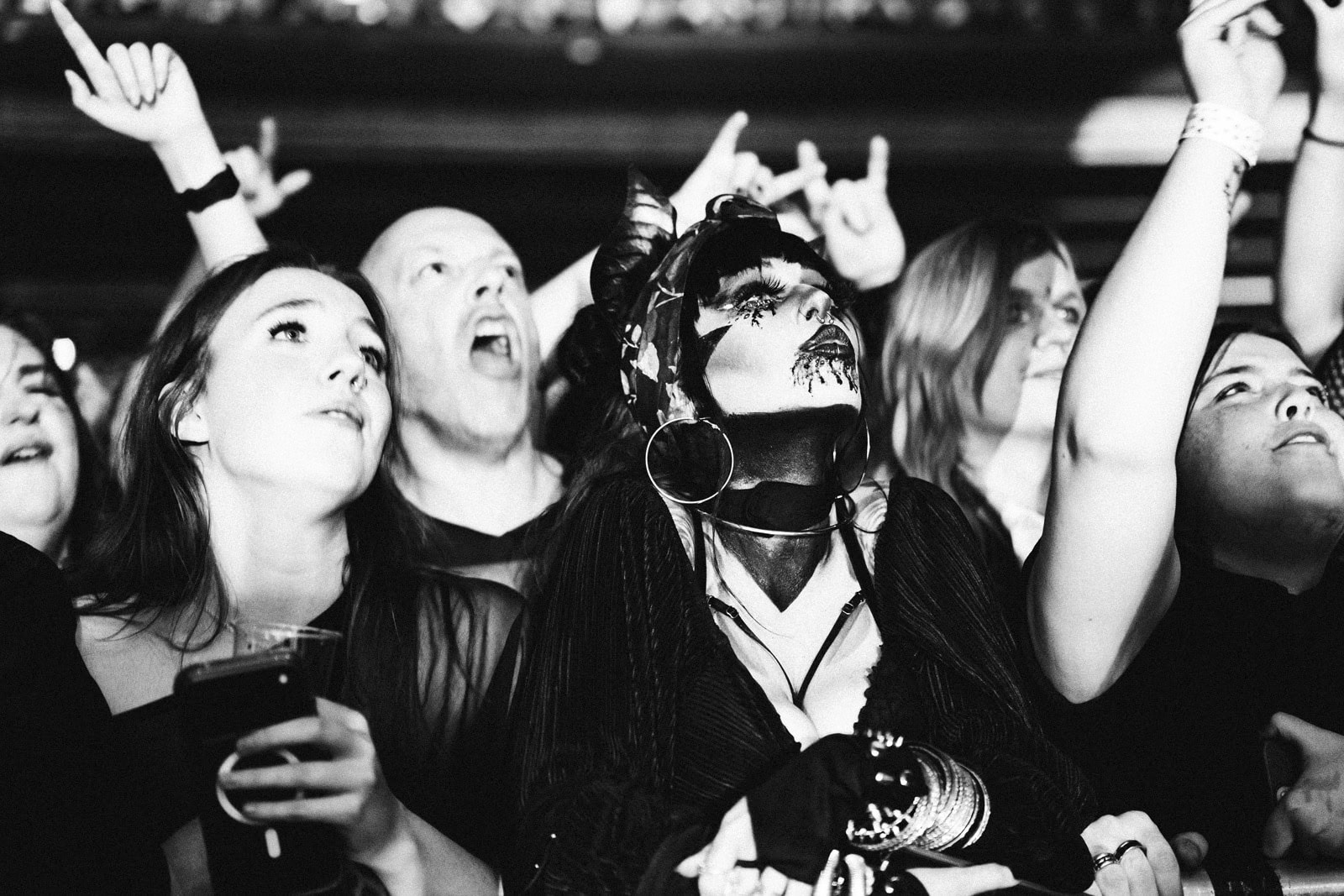 Black-and-white shot of Creeper fans singing at the barrier, one in a skull mask, at the O2 Forum Kentish Town
