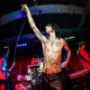 Shirtless, tattooed Remington Leith reaching up to the Barfly ceiling as Palaye Royale play behind him